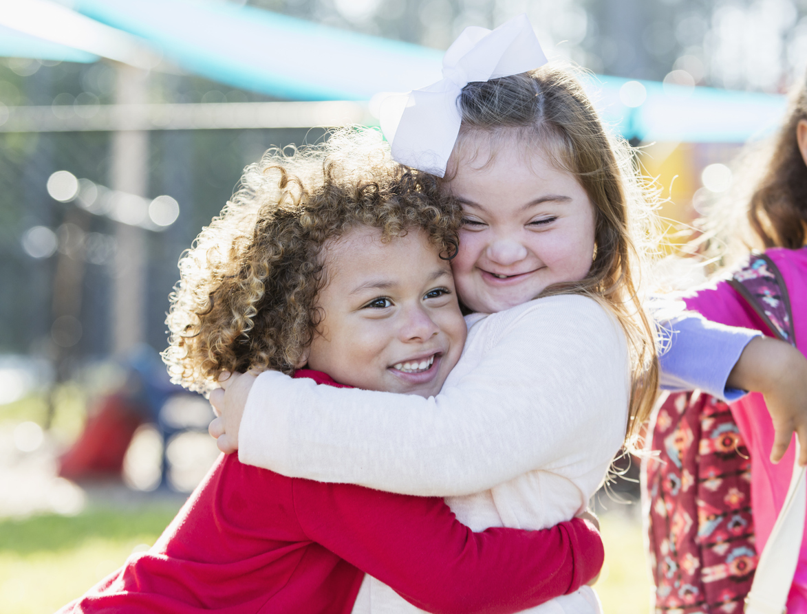 Little Girl With Down Syndrome And Boy Hugging